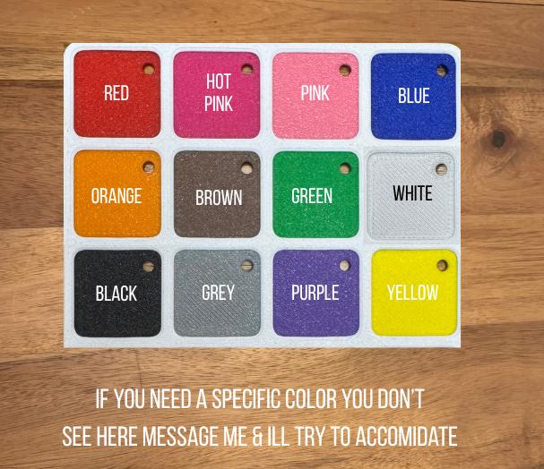 May include: A rectangular white display board featuring twelve square colour swatches with rounded corners, each containing a small hole. The colours include red, hot pink, pink, blue, orange, brown, green, white, black, grey, purple, and yellow.